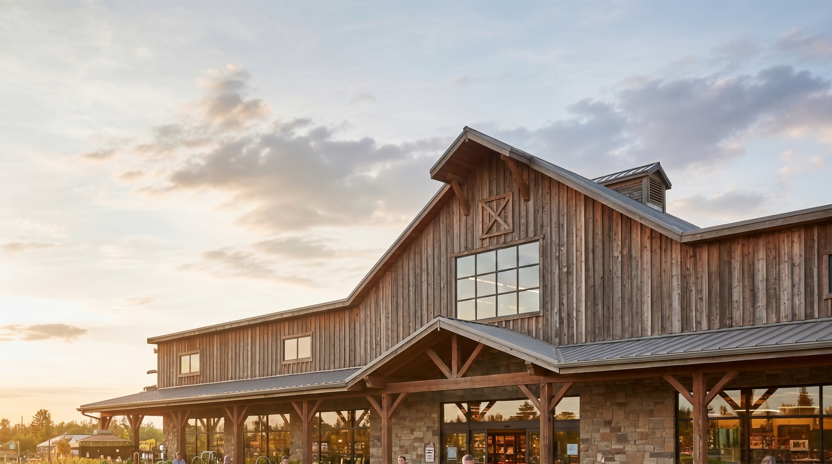 A timber-and-stone farm and garden retail store at golden hour
